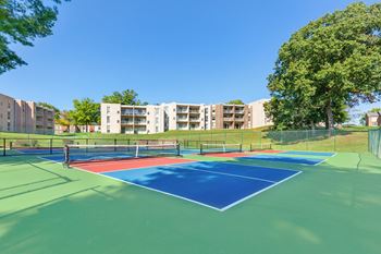 two tennis courts with apartments in the background
